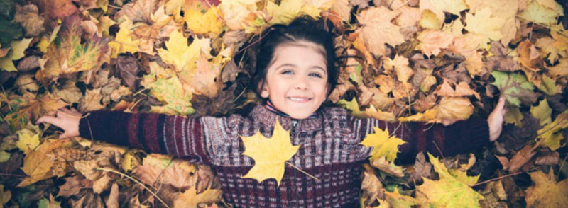 Girl playing in a pile of leaves
