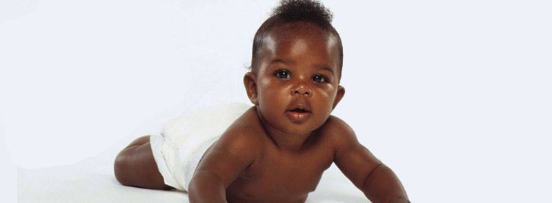 African American baby crawling on floor