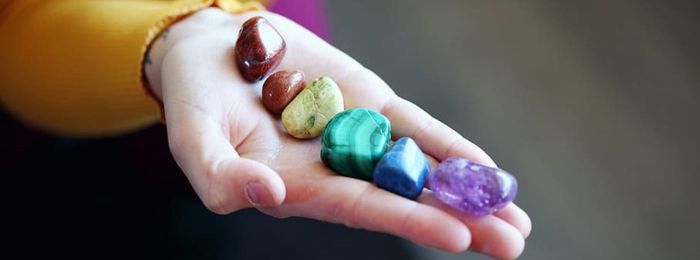 A hand with a variety of crystals for healing